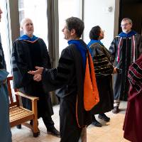 Faculty talking before ceremony